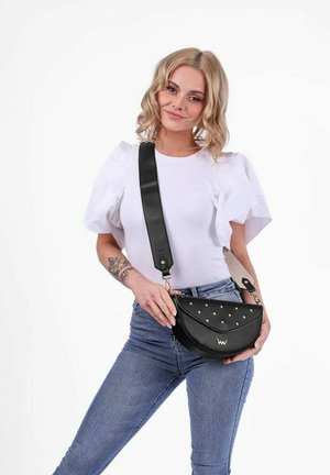 Černá kožená crossbody taška s oblým tvarem, ozdobena cvočky a s odnímatelným popruhem. Hladký povrch s moderním překlopným víkem.