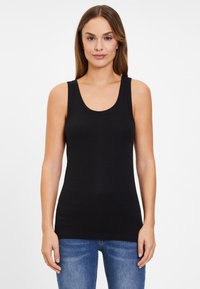 Black tank top with a scooped neckline and wide shoulder straps, made of a smooth, stretchy material, paired with fitted blue jeans.