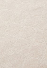 Strukturert beige stoff med et geometrisk mønster, myke fibre og en subtil glans, som skaper en varm og innbydende overflate.