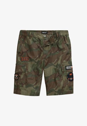 Spodnie cargo w zielonym i brązowym kamuflażu, z wieloma kieszeniami, pomarańczowym haftem i naszywkami w stylu militarnym na boku.