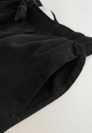 Schwarze Baumwoll-Shorts mit elastischem Bund, ausgestattet mit Seitentaschen und einer glatten Textur. Einfaches Design ohne Muster oder Akzente.