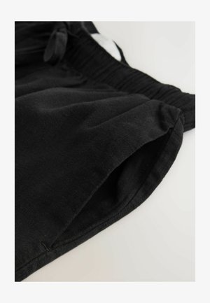 Schwarze Baumwoll-Shorts mit elastischem Bund, ausgestattet mit Seitentaschen und einer glatten Textur. Einfaches Design ohne Muster oder Akzente.