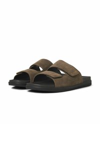 Sandali in suede marrone con due cinturini incrociati, punta aperta, suola imbottita e suola in gomma nera testurizzata.