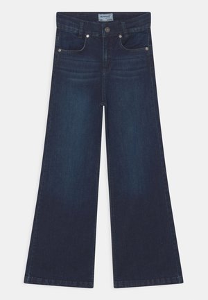 Jeans de pierna ancha en denim índigo oscuro. Cuenta con cinco bolsillos, herrajes plateados y un corte recto desde la cintura hasta el dobladillo.