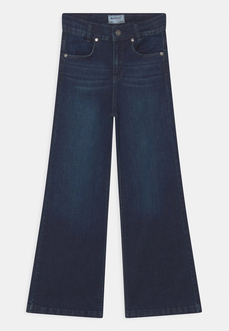 Jean large en denim indigo foncé. Comprend cinq poches, des accessoires en argent et une coupe droite de la taille à l'ourlet.