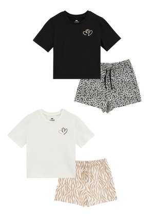 Dva kompleta udobnih oblačil: črna majica s srčnim motivom, kombinirana s črnimi in belimi kratkimi hlačami z leopardjim vzorcem; bela majica s srčnim motivom, kombinirana s bež kratkimi hlačami z zebra vzorcem.
