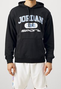 Felpa con cappuccio nera in cotone misto. Presenta una grafica "JORDAN" blu e bianca, tasca a marsupio e polsini e fondo a costine.