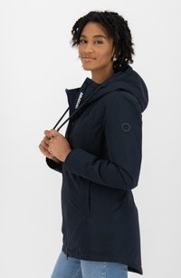Giacca impermeabile blu marina con cappuccio, materiale testurizzato, chiusura con bottoni e zip, corde di regolazione e tasche laterali.
