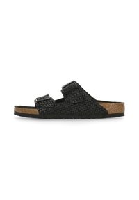 Sandali a scivolo in pelle intrecciata nera con due cinturini regolabili, suola in sughero e suola in gomma. Parte superiore texturizzata e design piatto.