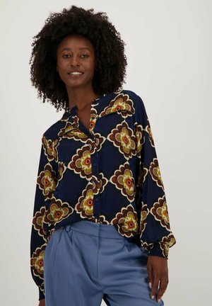 Marineblauw overhemd met knopen en een kleurrijk bloemmotief, lange mouwen en elastische manchetten, gecombineerd met lichtblauwe broek. Soepele stofstructuur.