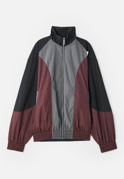 Color-blocked jacket featuring maroon, black, and gray panels. Lightweight fabric, high collar, and elastic cuffs with a full front zipper.