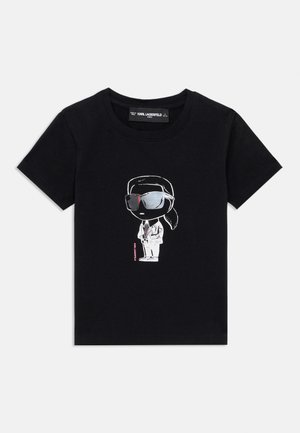 Black cotton T-shirt featuring a cartoon graphic of a figure in sunglasses and suit, with pink text reading "Karl Lagerfeld" below.