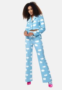 A blue cropped jacket and matching flared pants with white cloud patterns. The outfit features slim-fit tailoring and contrasting pink high heels.