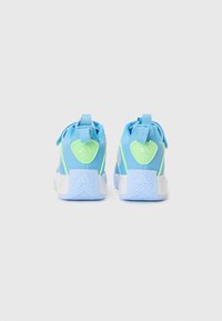 Baskets de sport bleues avec des accents vert clair. Tige en mesh, talon robuste et semelle en caoutchouc blanc texturé avec un motif en zigzag.