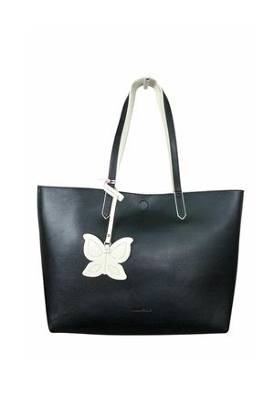 Borsa tote in pelle nera con manici bianchi e un ciondolo bianco a forma di farfalla appeso a una tracolla.