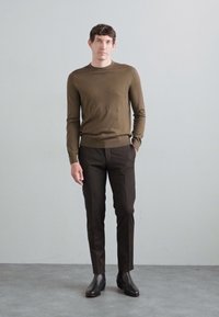 Bordeaux lange mouwen shirt en donkere broek, gedragen met zwarte enkellaarsjes. Strak ontwerp, gladde textuur, minimalistische stijl, neutrale kleuren.