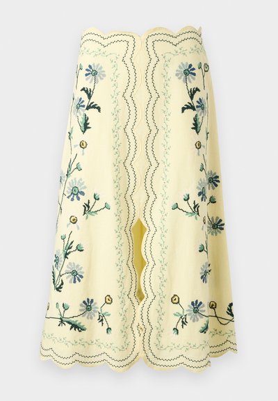 Κίτρινη φούστα μέχρι το γόνατο με κυματιστές άκρες και κεντήματα με λουλούδια σε μπλε, πράσινο και κίτρινο, με κεντρική σχισμή και διακοσμητικές ραφές.