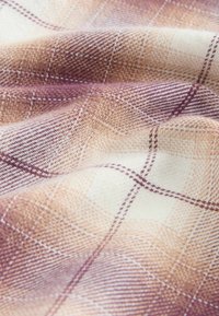 Gewebter Stoff in Schattierungen von Creme, Beige und Mauve mit einem karierten Muster. Weiche Textur mit sichtbaren Fasern, die einen subtilen Tiefeneffekt erzeugen.