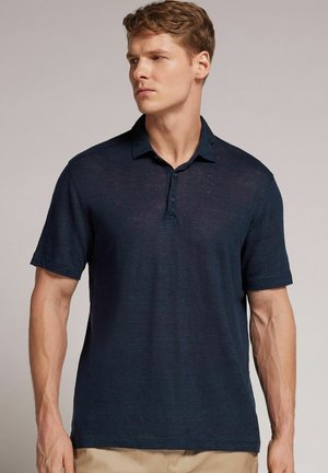 Navy blue polo shirt with a buttoned collar, short sleeves, and a textured finish. Made from lightweight fabric, featuring a relaxed fit.