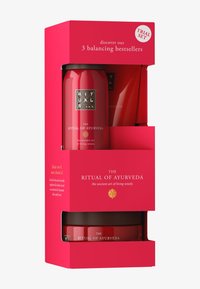 Confezione di un set di prova rosso con tre contenitori, caratterizzata da rifiniture dorate e una finitura lucida. Il testo mette in evidenza i best-seller e il nome del marchio.