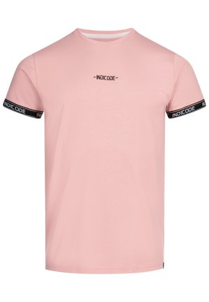 Lyserød bomulds T-shirt med rund halsudskæring, korte ærmer med sorte detaljer og et lille sort 'INDICODE' logo på brystet.
