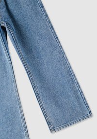 Jeans in denim blu chiaro con un design a gamba dritta, caratterizzati da cuciture visibili, una texture liscia e un orlo piegato sul fondo.