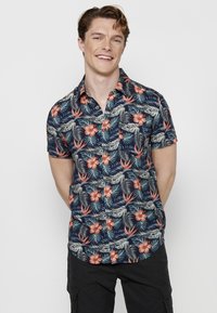 Korte mouwen overhemd met een marineblauwe basis, met een levendig bloemen- en bladerenpatroon in koraal, groen en grijstinten.