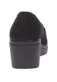 Scarpa in suede nera con punta rotonda e tacco spesso. Il tacco è texturizzato e alto circa 5 cm con una base liscia.