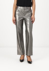 Metallic silver wide-leg trousers with a sleek surface, front pockets, and a subtle sheen, paired with black patent heels.
