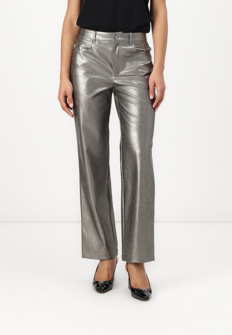 Metallic silver wide-leg trousers with a sleek surface, front pockets, and a subtle sheen, paired with black patent heels.