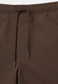 Braune Shorts aus strukturiertem Stoff, mit einem elastischen Bund und Kordelzug sowie dezenten Nähdetails.