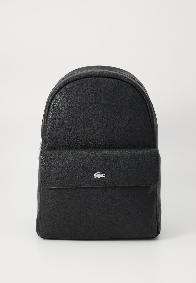 Rucsac din piele neagră cu o formă rotunjită. Dispune de un buzunar cu clapetă în față și un accent cu logo argintiu. Textură netedă cu închidere cu fermoar.