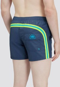 Shorts da bagno navy con strisce laterali gialle e blu, vita elastica e tasca posteriore con logo blu. Tessuto leggero.