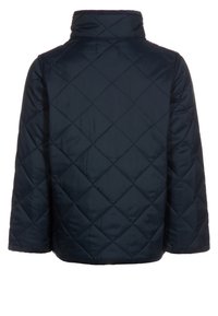 Giacca trapuntata blu navy con cuciture a diamante, maniche lunghe e colletto rialzato, mostrata da dietro.