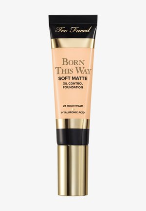 Tube de fond de teint Too Faced Born This Way Soft Matte avec bouchon doré et noir, étiqueté contrôle de l'huile, tenue 24 heures, acide hyaluronique.