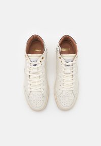 Witte hoge sneakers van leer met geperforeerde details, platte veters, gouden accenten en een padded bruine binnenkant.