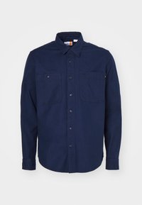 Camicia button-up blu navy in cotone, con colletto a punta, maniche lunghe, due tasche sul petto e orlo dritto.