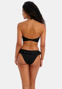 Black bikini set featuring a strapless top with a clip closure and high-waisted bottoms with a ruffled accent along the waistband.