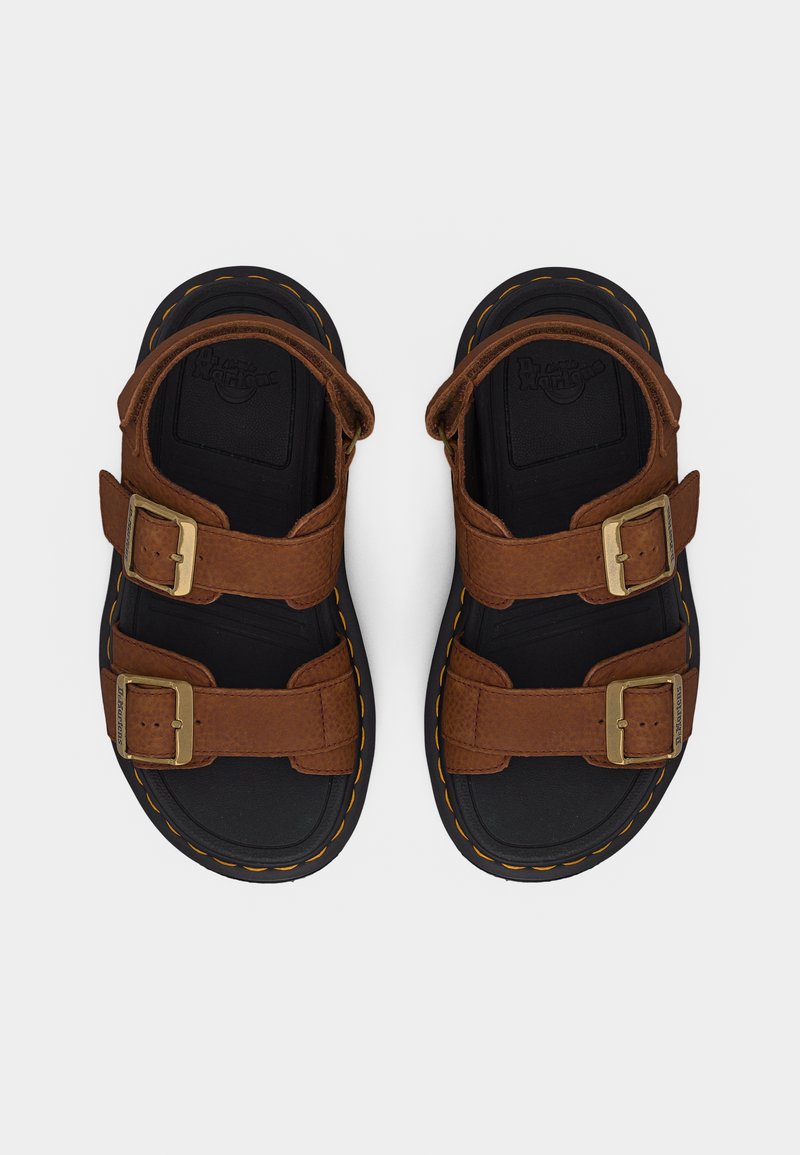 Schwarze Sandalen mit dicker Sohle, braunen Riemen mit doppelter Schnalle und gelben Nähten, von oben gezeigt.