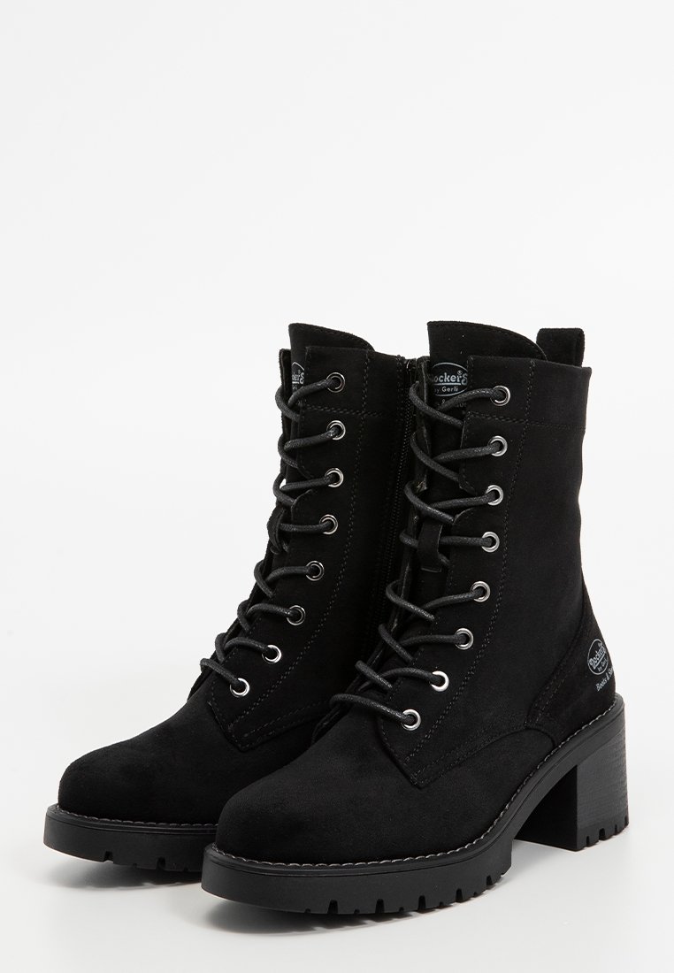 Botines de ante negro hasta el tobillo con punta redondeada, cordones en la parte delantera y cremallera lateral. Presentan un tacón bloque robusto y suela de goma.