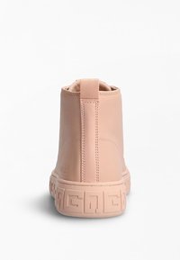 Stivale alla caviglia in pelle rosa con suola testurizzata, un piccolo tassello sul retro e cuciture visibili. Design minimalista con forma arrotondata.