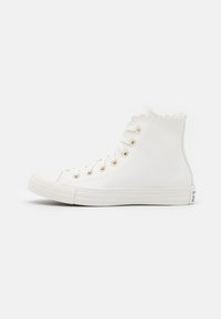 Weiße High-Top-Sneaker aus glattem Material mit gewellten Kanten, goldenen Ösen und Gummisohle. Klassisches Schnürdesign.