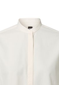 White collared shirt featuring a button closure, smooth texture, and a minimalist design with a subtle sheen. Tag visible inside collar.