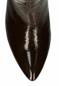 Escarpin en cuir verni noir avec un bout pointu, finition brillante et texture lisse. Aucun motif ou détail matériel visible.