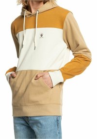 Felpa con cappuccio caratterizzata da un design a blocchi di colore in beige, bianco e senape, con tasca a marsupio e cappuccio regolabile con cordino. Texture liscia.