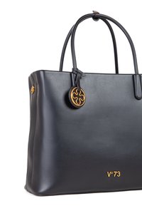 Borsa tote in pelle nera con due manici, accentuazione circolare in tono oro e logo impresso sul davanti. Texture liscia con una forma strutturata.