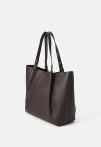 Sac fourre-tout en cuir texturé marron foncé avec deux poignées, ouverture sur le dessus et une forme légèrement structurée. Design minimaliste sans matériel visible.