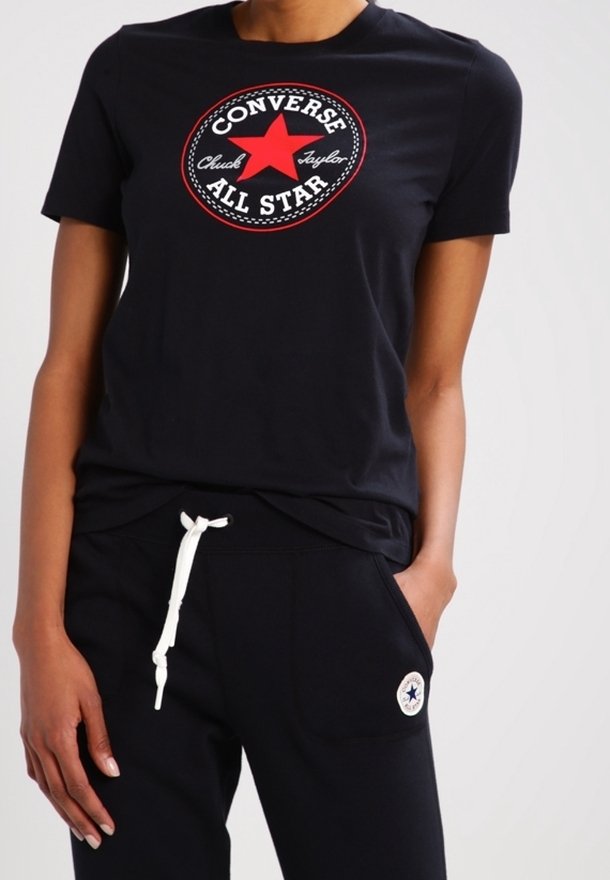 Svart bomullströja med en röd stjärnlogotyp och texten "Converse" och "All Star", rund hals och korta ärmar.