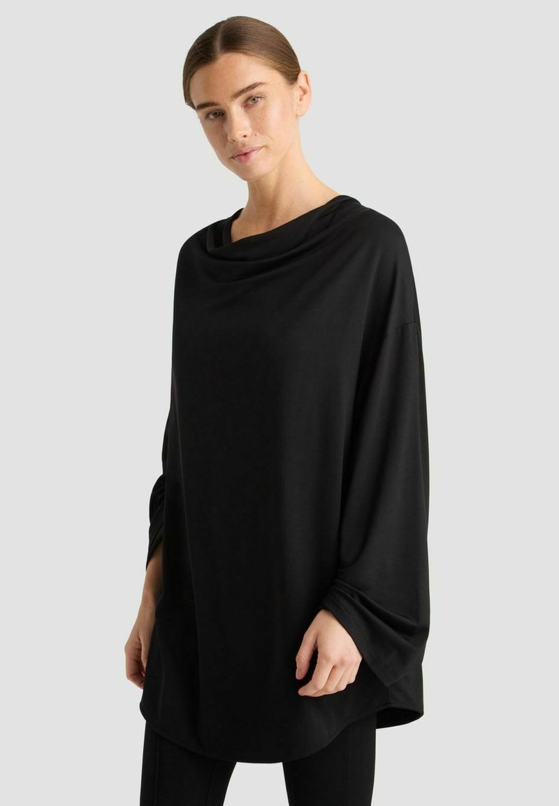 Schwarzes, übergroßes Oberteil mit einem Schalkragen und langen, weiten Ärmeln. Hergestellt aus weichem Stoff, mit einem minimalistischen Design ohne Muster.