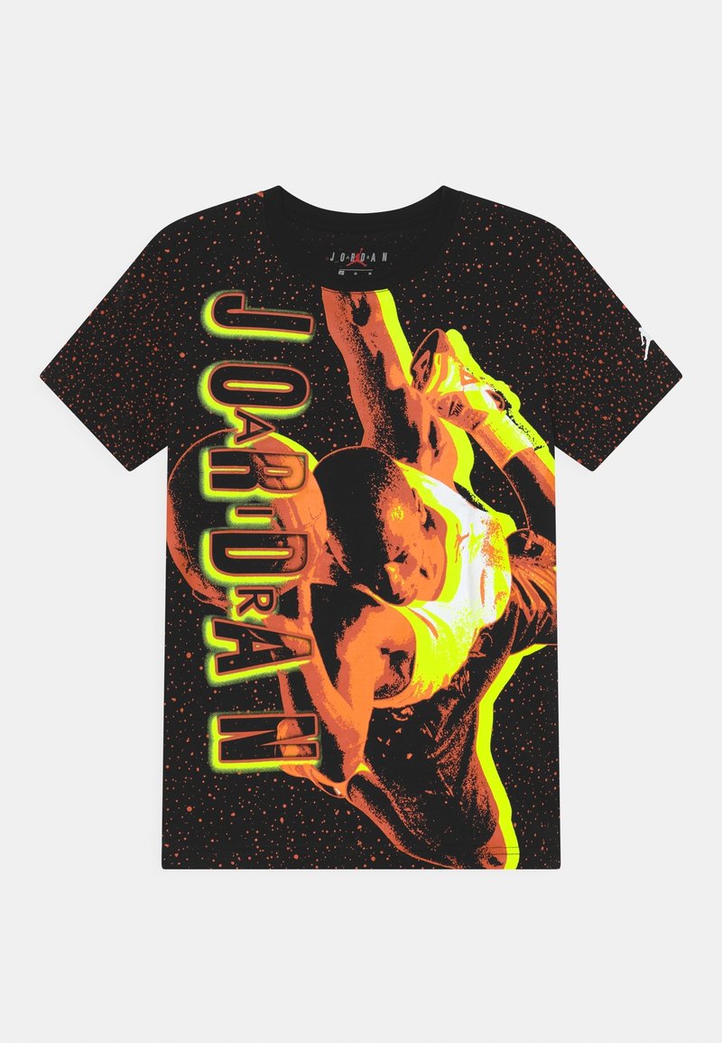 Camiseta negra con un diseño vibrante con acentos en naranja y verde, que muestra a un jugador de baloncesto en acción, con el texto "JORDAN" destacado.